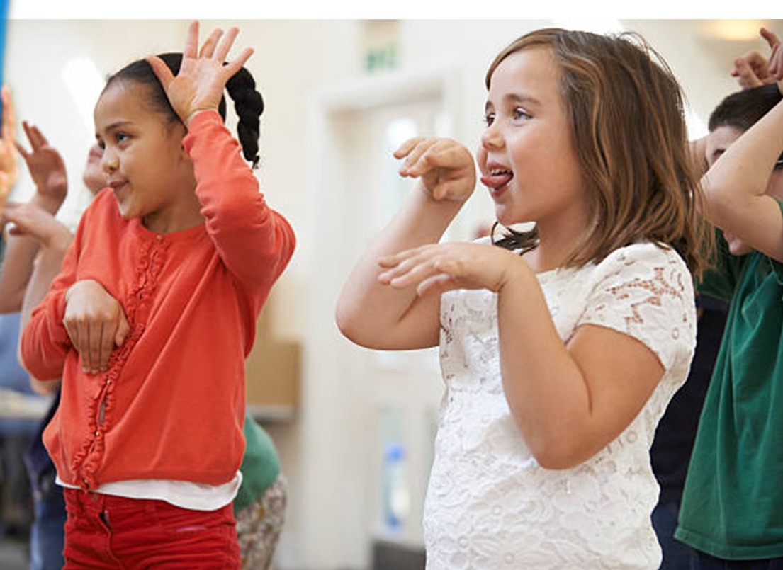 Two students practising expressive drama gestures together in a group session